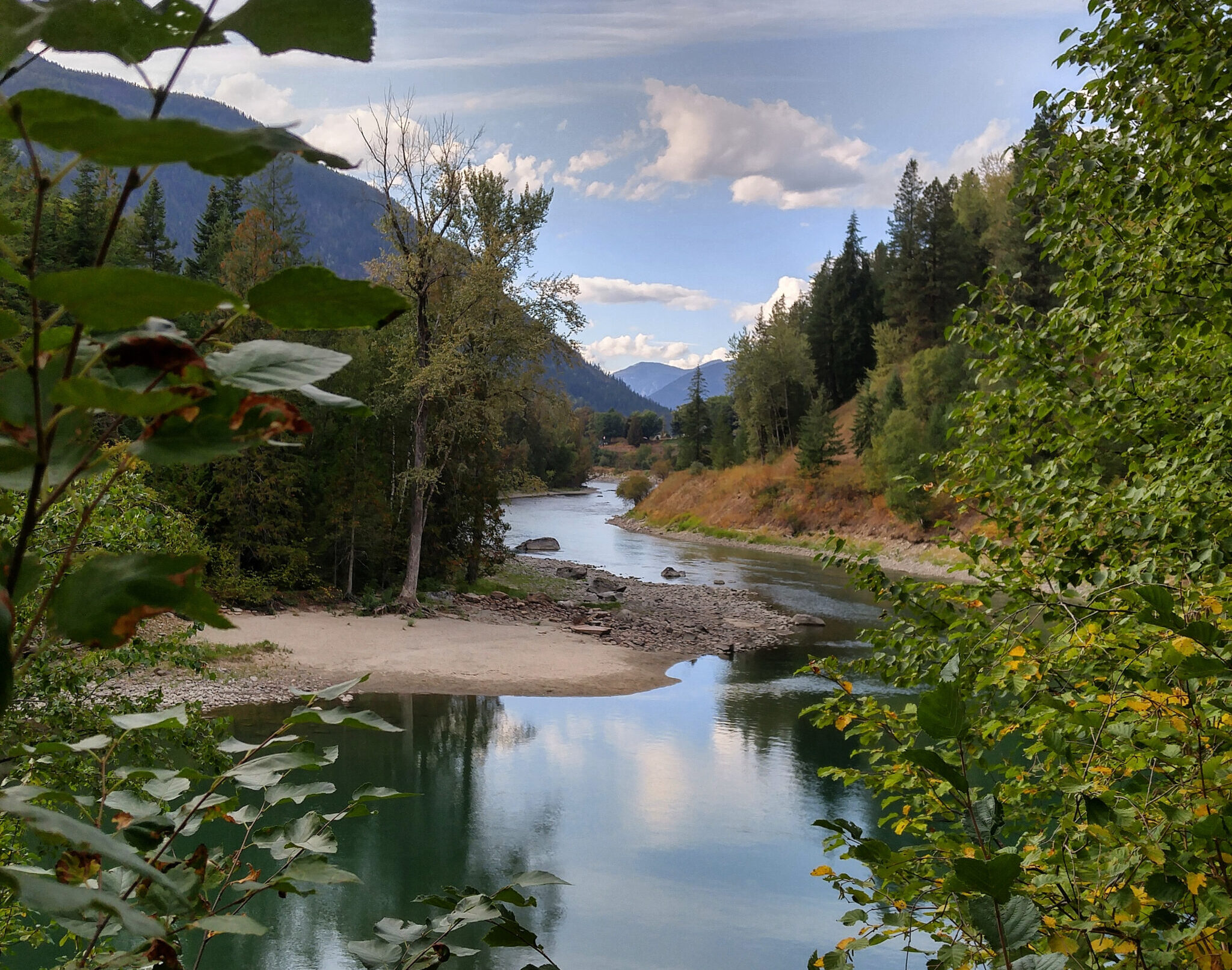 Scenic view of the Slocan River winding through lush green forests in British Columbia