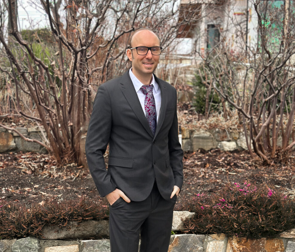 Image of Benjamin Fox standing in a suite on a rock pathway with a garden bed behind him